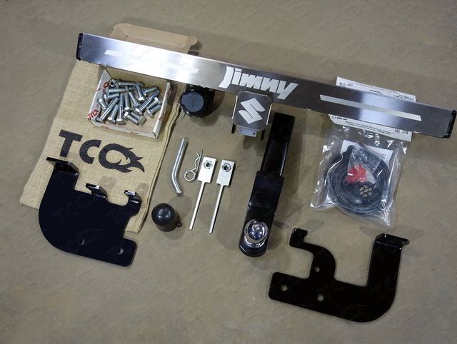 Фаркоп оцинкованный под американский квадрат ТСС для Suzuki Jimny 2012-2018 с накладкой с надписью Jimny (нерж. шар). Артикул TCU00093N