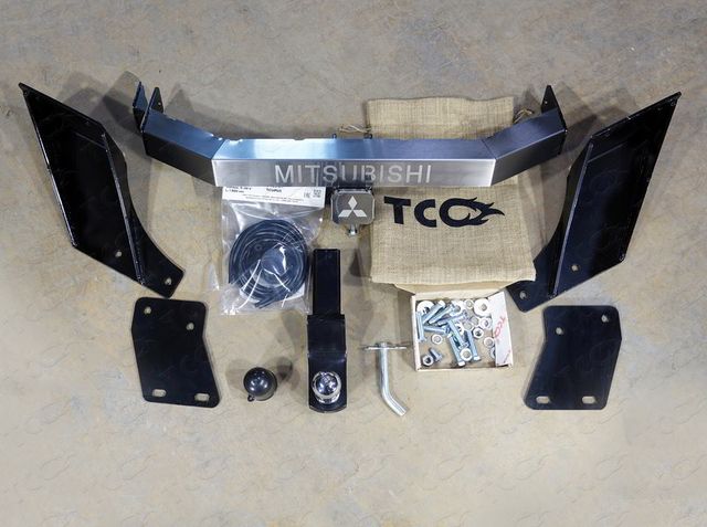 Фаркоп ТСС оцинкованный под американский квадрат для Mitsubishi L200 V 2015-2026 с накладкой с надписью Mitsubishi. Артикул TCU00113