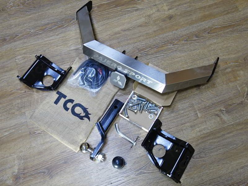 Фаркоп ТСС оцинкованный под американский квадрат с накладкой с надписью Pajero Sport для Mitsubishi Pajero Sport III до рестайлинга 2016-2020 (нерж. шар). Артикул TCU00117N